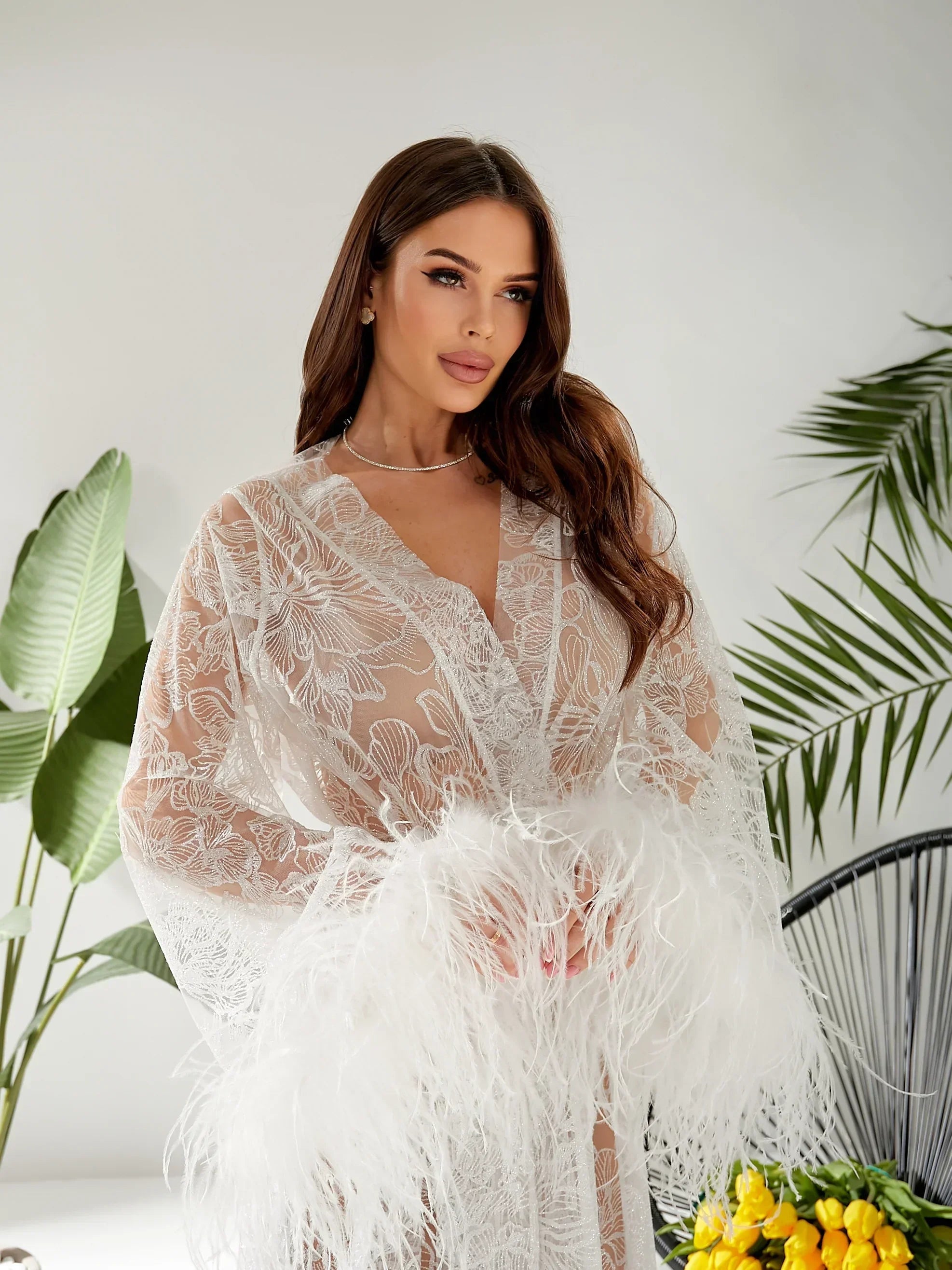 Bride wearing sheer lace bridal robe with feather trim, perfect for wedding morning