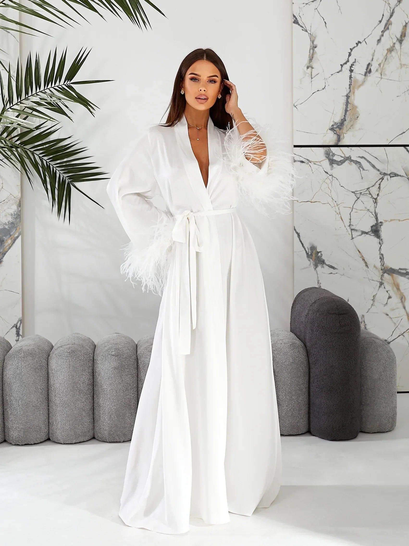 Bride wearing long white silk bridal robe with feather sleeves, perfect for wedding morning