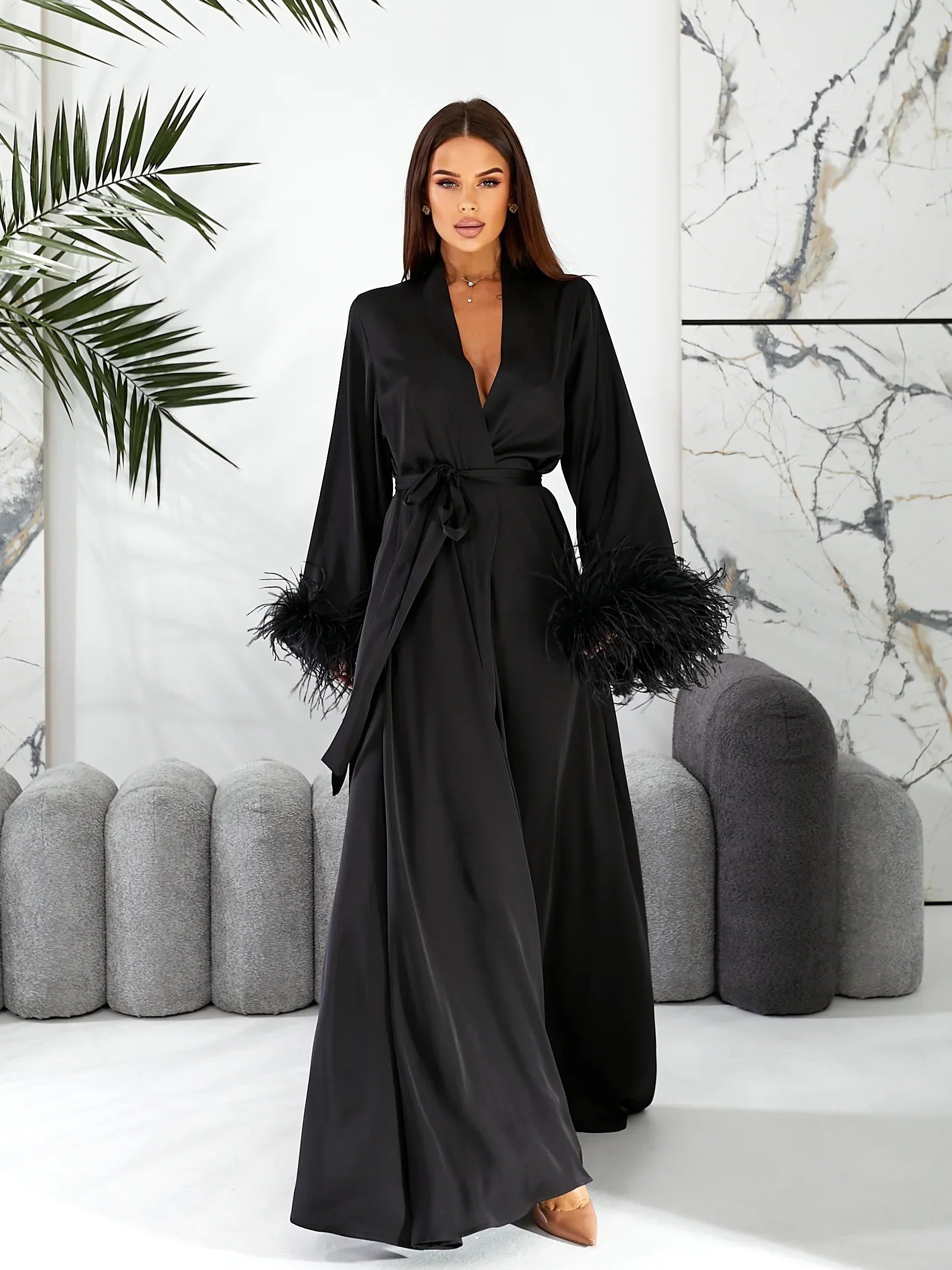 Model in long black silk bridal robe with feathered sleeves, perfect for wedding morning.