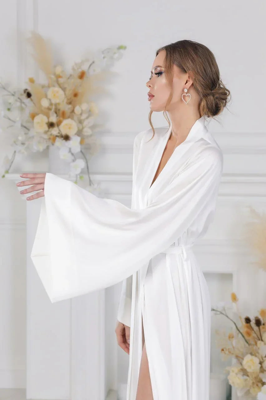 Bride in white silk bridal robe with wide sleeves, perfect for wedding morning photos