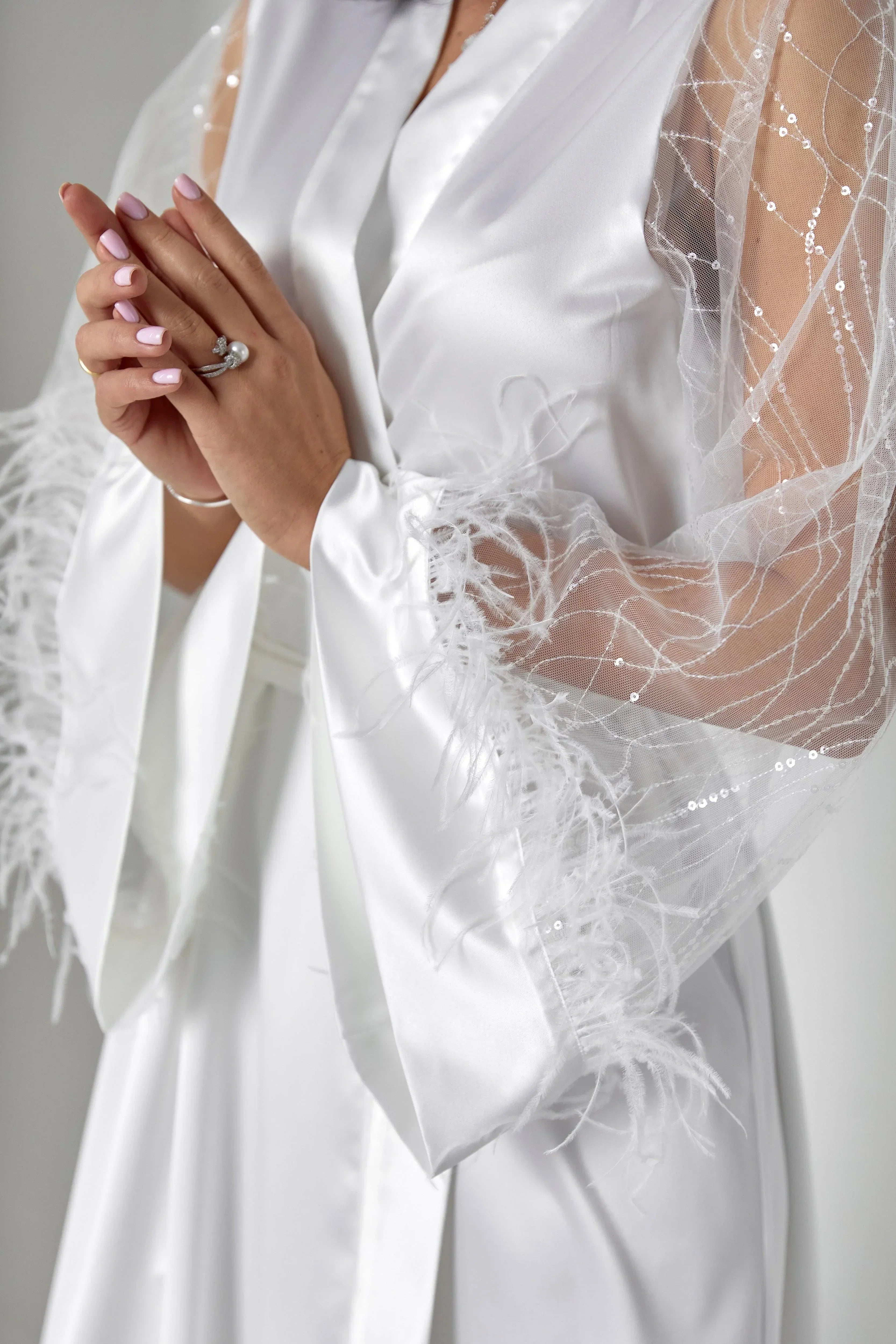 White silk bridal robe with sheer lace and feather trim, ideal for wedding morning.