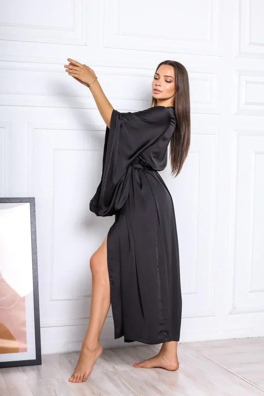 Woman in long black silk robe, elegant bridal loungewear for wedding morning.