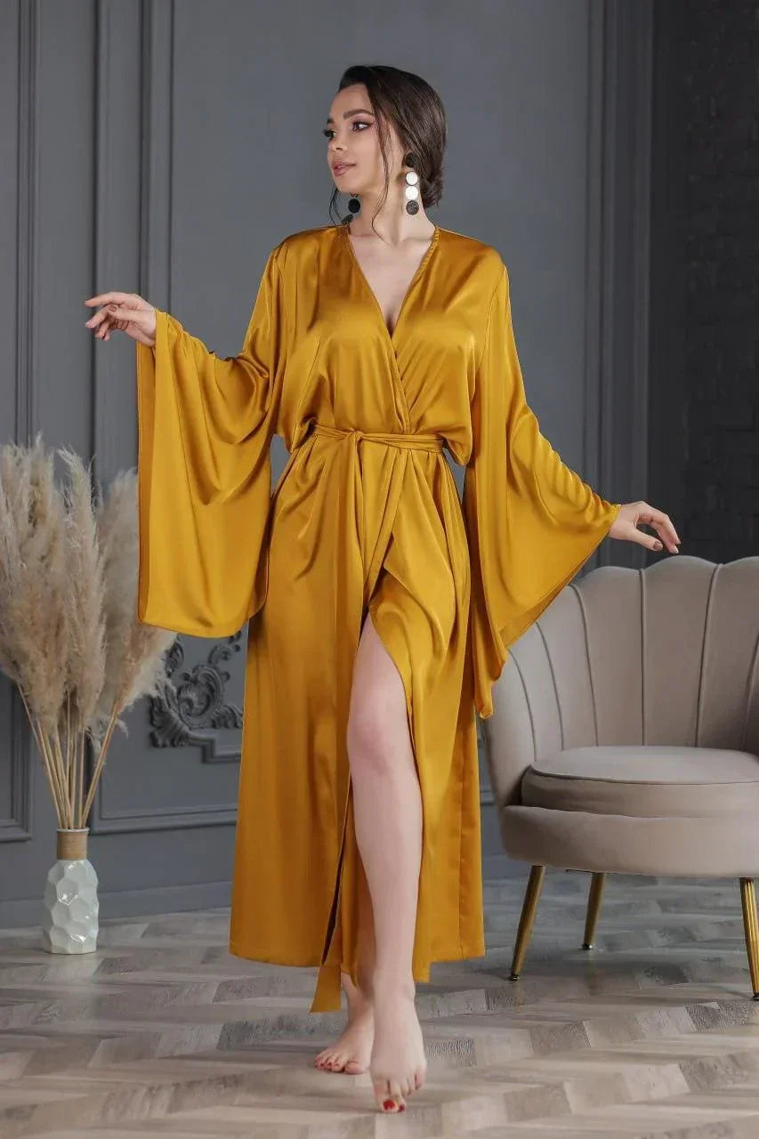 Woman in mustard yellow silk bridal robe with wide sleeves, perfect for wedding morning