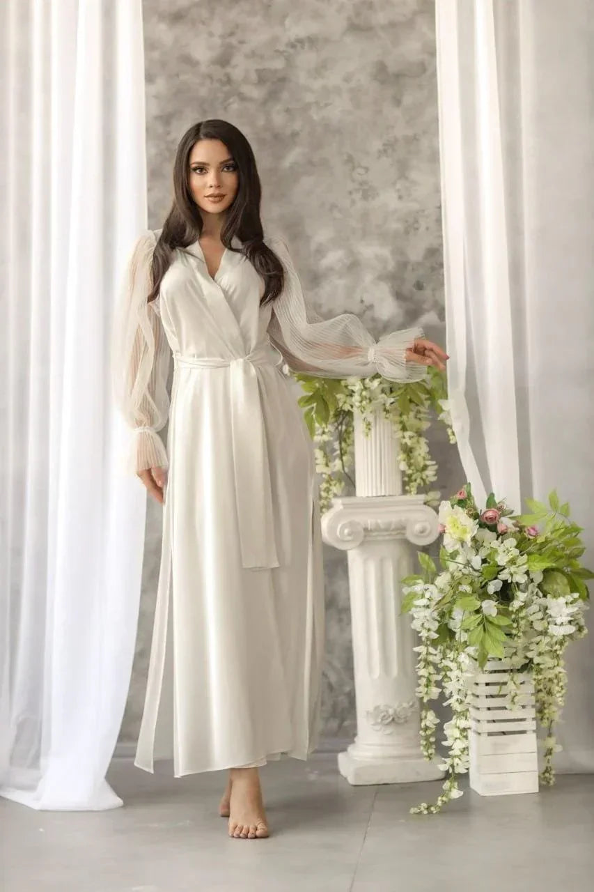 Bride wearing long white silk bridal robe with sheer sleeves, perfect for wedding morning