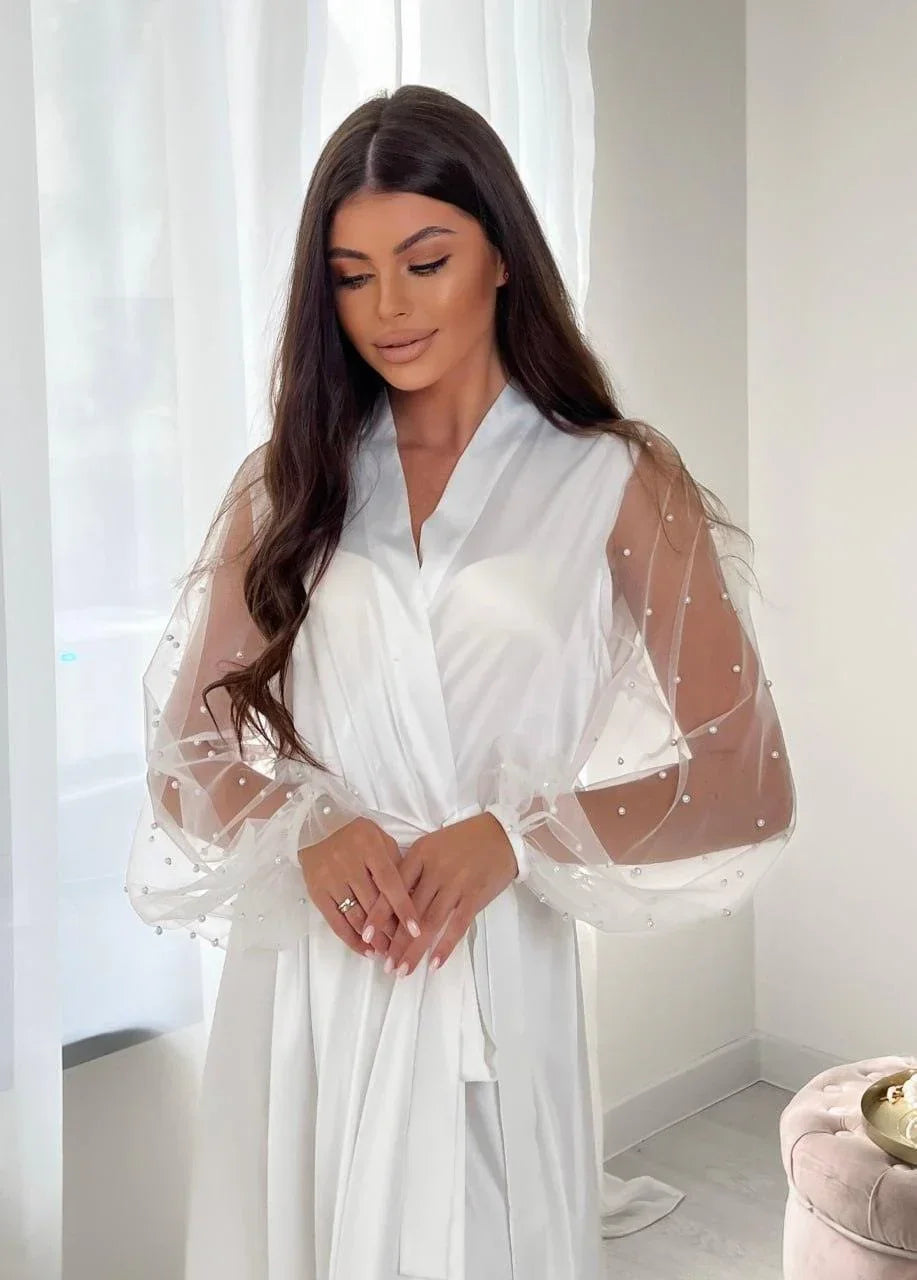 Bride in white silk bridal robe with sheer pearl lace sleeves, perfect for wedding morning